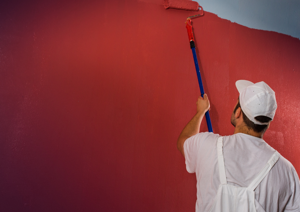Professional painter preparing and rolling paint on an interior wall